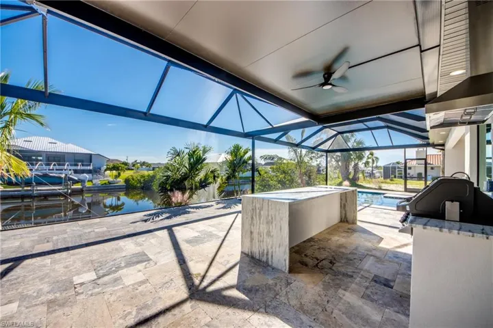 View of patio / terrace with a water view, glass enclosure, a dock, and ceiling fan