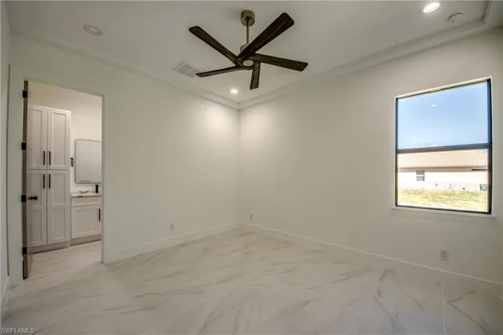 Empty room with crown molding and ceiling fan