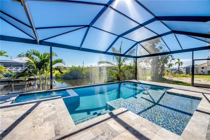 View of pool with a lanai, a patio, and a water view