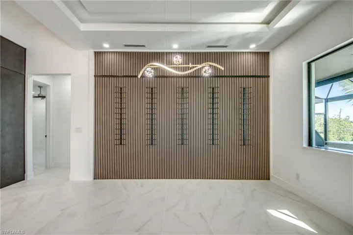 Unfurnished room featuring an inviting chandelier and a raised ceiling