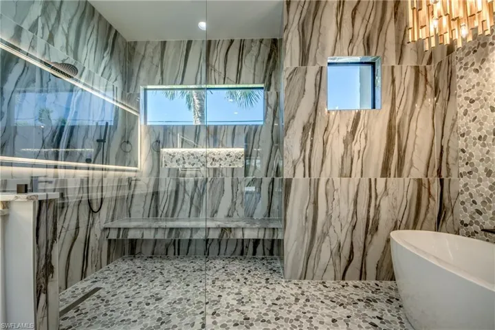 Bathroom with independent shower and bath and tile walls