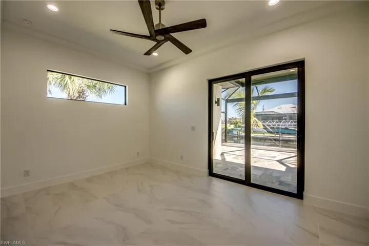 Empty room featuring ceiling fan, a healthy amount of sunlight, and crown molding