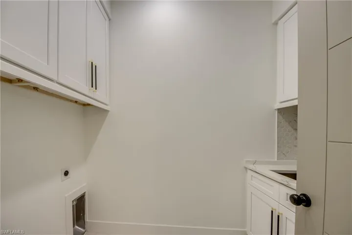 Clothes washing area featuring cabinets and electric dryer hookup