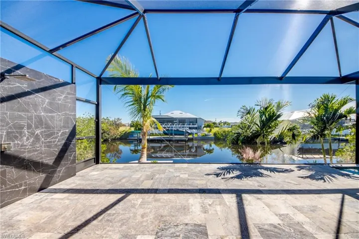 View of patio / terrace with a dock, glass enclosure, and a water view
