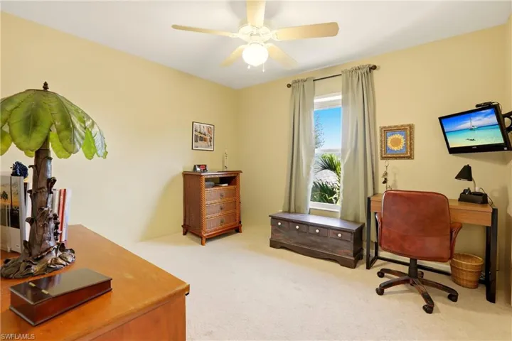 Home office featuring light colored carpet and ceiling fan