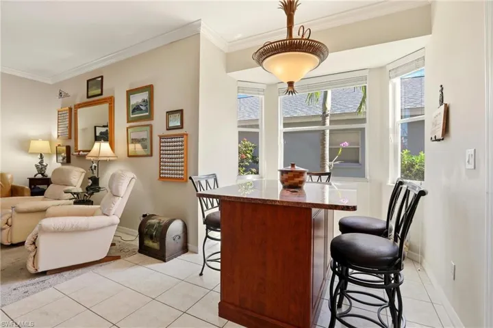 Dining room featuring light tile patterned floors and crown molding