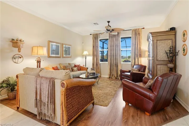Living room featuring crown molding, light wood-style floors, and ceiling fan