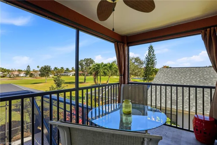 Balcony featuring a ceiling fan, golf course view, and a sunroom