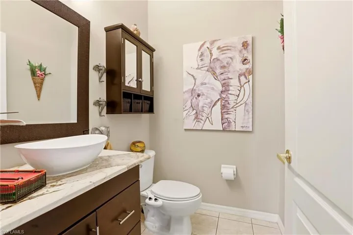 Half bath featuring vanity and light tile patterned flooring