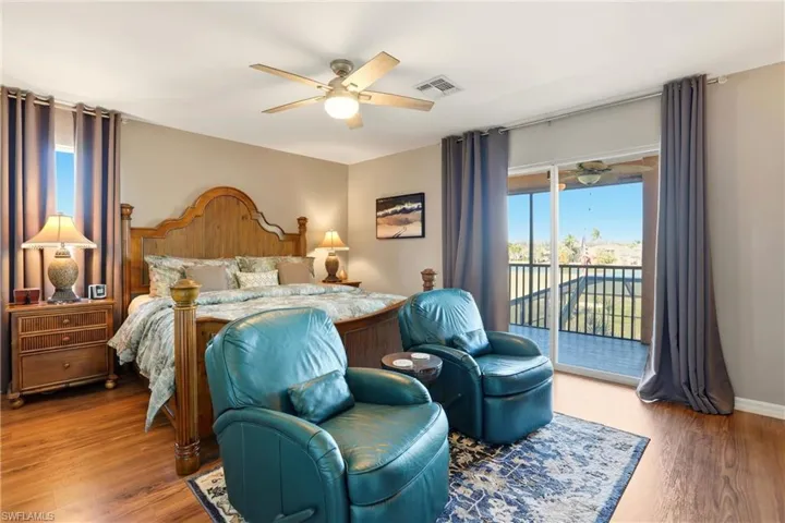 Bedroom featuring access to exterior, wood finished floors, multiple windows, and ceiling fan