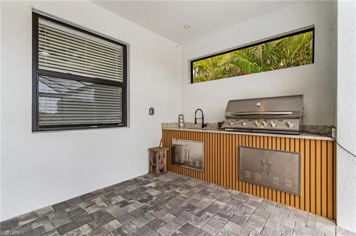 View of patio featuring grilling area, an outdoor kitchen, and a sink