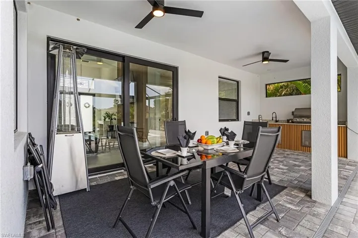 View of patio with a ceiling fan, outdoor dining space, exterior kitchen, and area for grilling