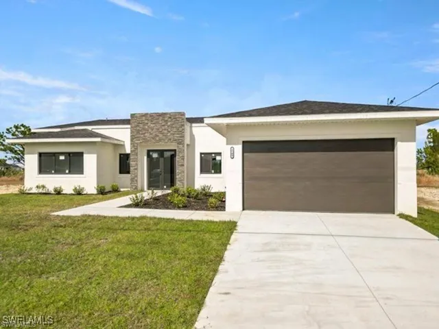 View of front facade featuring stone siding, stucco siding, driveway, and a front lawn