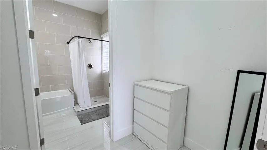 Bathroom featuring a stall shower and a tub