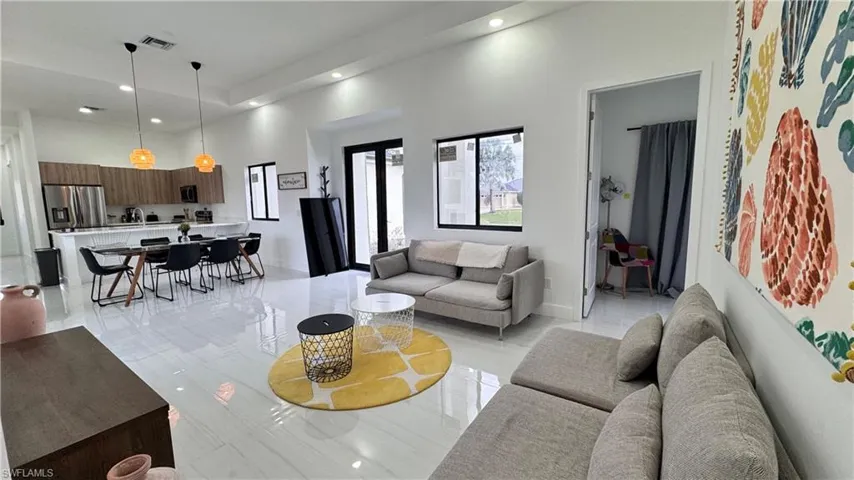 Living area featuring a high ceiling and recessed lighting