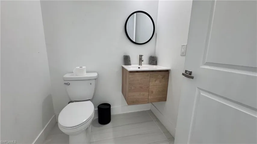 Half bath featuring vanity and baseboards