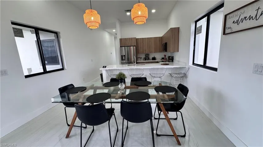 Dining area with recessed lighting, light wood-type flooring, and a high ceiling