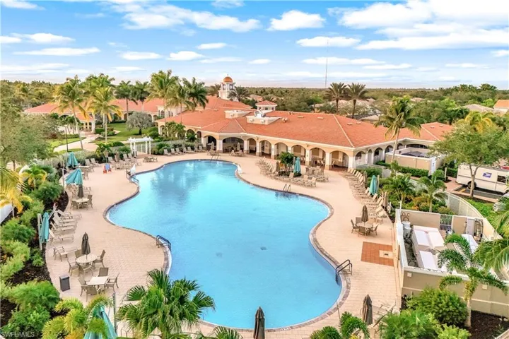 Expansive resort-style swimming pool featuring a curved design and paver decking