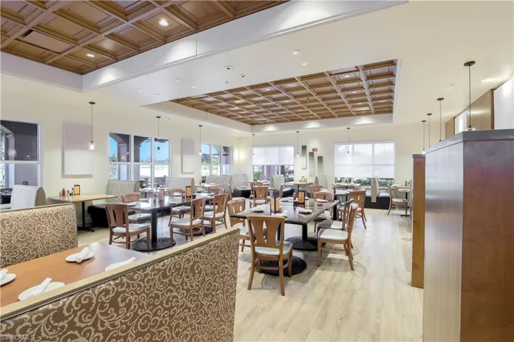 Spacious dining area featuring recessed lighting, pendant fixtures, wood-finish flooring, and multiple window bays
