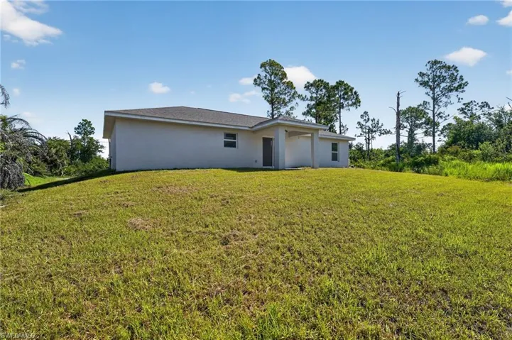 Contemporary single-story exterior featuring a covered entry, neutral stucco finish, and a dark shingle roof