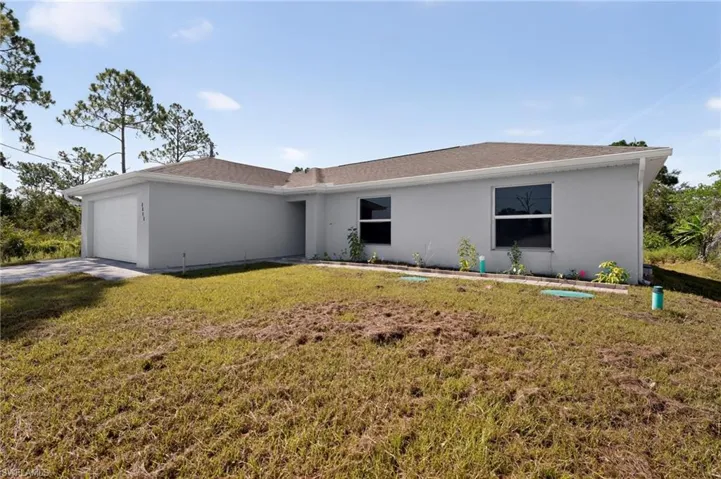 Contemporary single-story residence featuring a two-car garage, light-colored stucco exterior, and a brown shingle roof