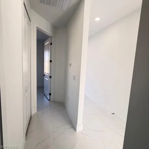 Corridor with light marble finish flooring and recessed lighting