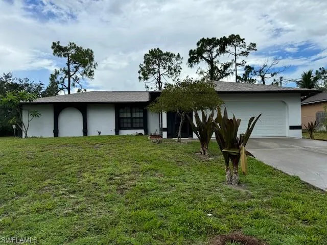 View of front of home with a front yard and a garage