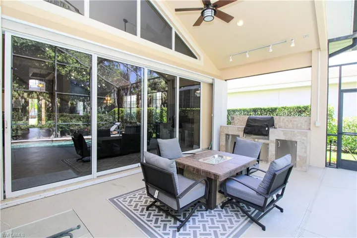 Sunroom / solarium with lofted ceiling, ceiling fan, track lighting, and a wealth of natural light