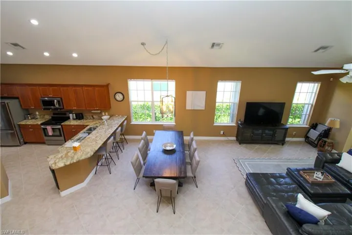 Living room featuring sink, light tile patterned floors, and ceiling fan