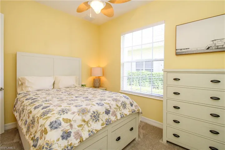 Bedroom with light colored carpet and ceiling fan
