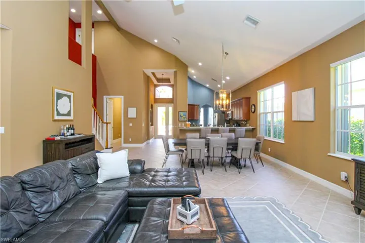 Tiled living room featuring an inviting chandelier and high vaulted ceiling