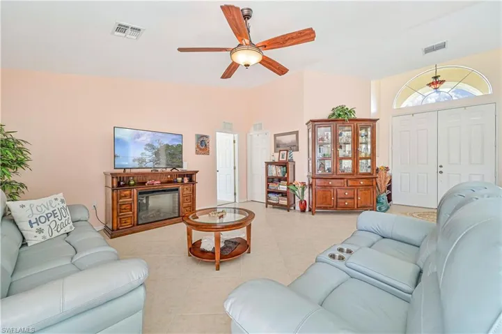Living room featuring tile flooring, vaulted ceiling, and ceiling fan