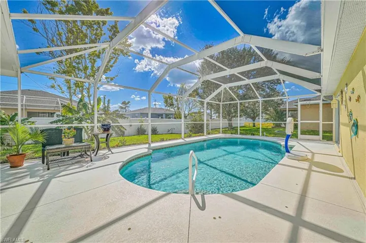 View of swimming pool with a patio area and screened enclosure