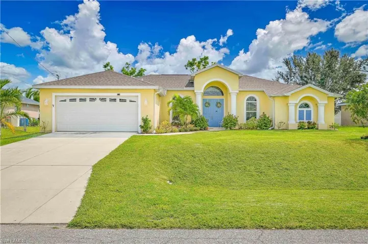 View of front of property featuring a garage and front lawn area