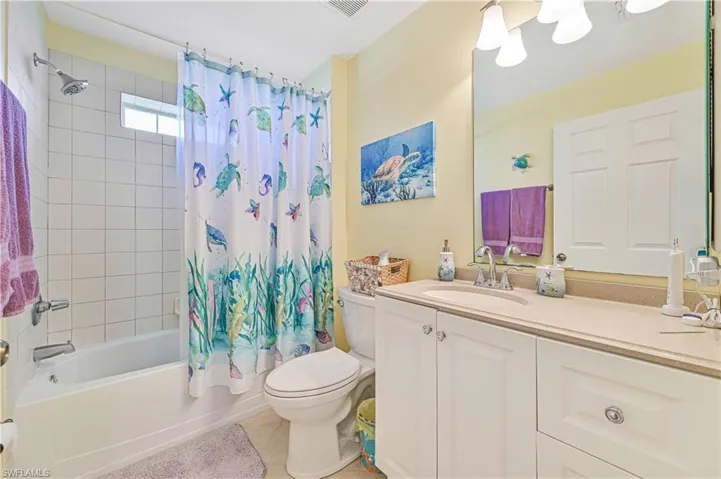 Full bathroom featuring tile patterned floors, toilet, vanity, and shower / bath combo