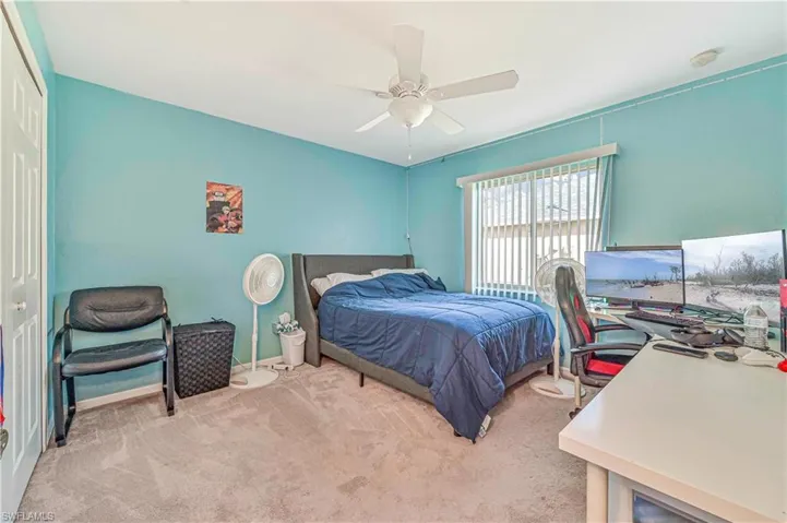 Bedroom with light carpet, ceiling fan, and a closet