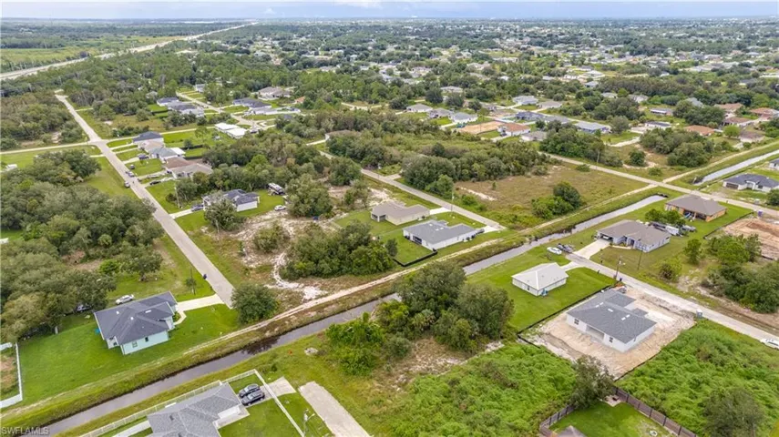 Aerial view of property and surrounding area with nearby suburban area