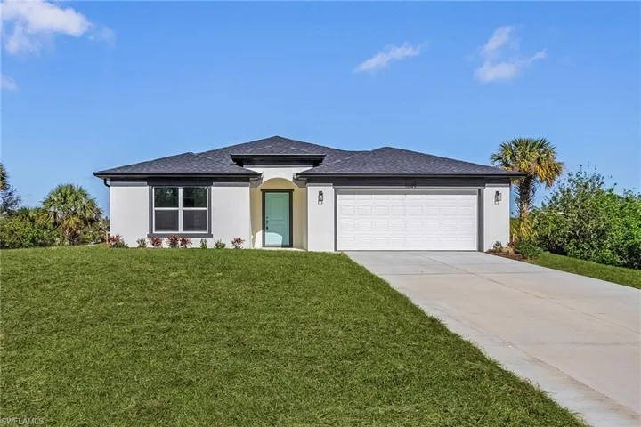 View of front of property featuring a front lawn and a garage