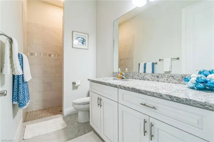 Bathroom with walk in shower, vanity, and toilet