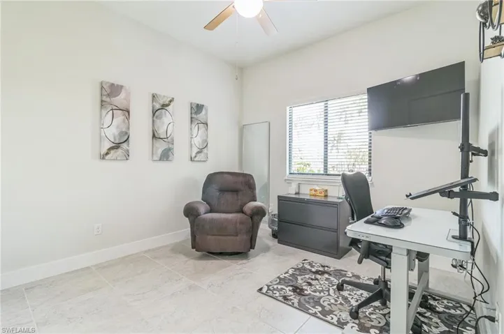 Office area with a ceiling fan and baseboards