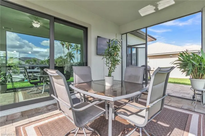 Sunroom / solarium with outdoor dining space, plenty of natural light, and ceiling fan