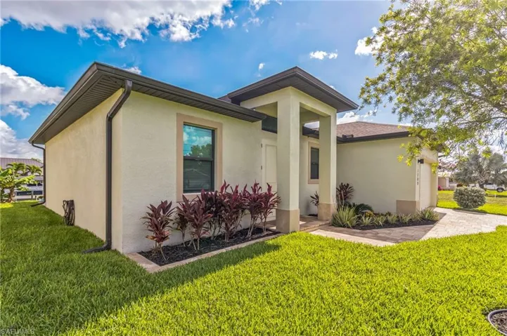View of front facade featuring stucco siding and a front lawn