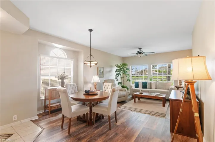 Abundant natural light beautifully highlights the rich tones of the vinyl wood flooring, creating a warm and inviting ambiance throughout the living space.
