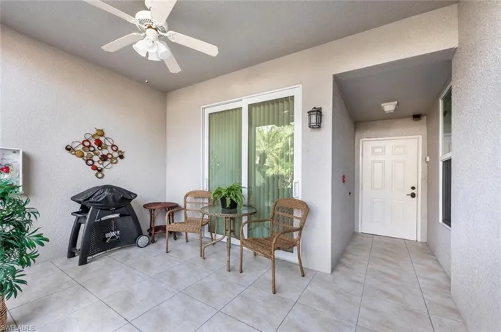 Entrance to property with ceiling fan and a patio area