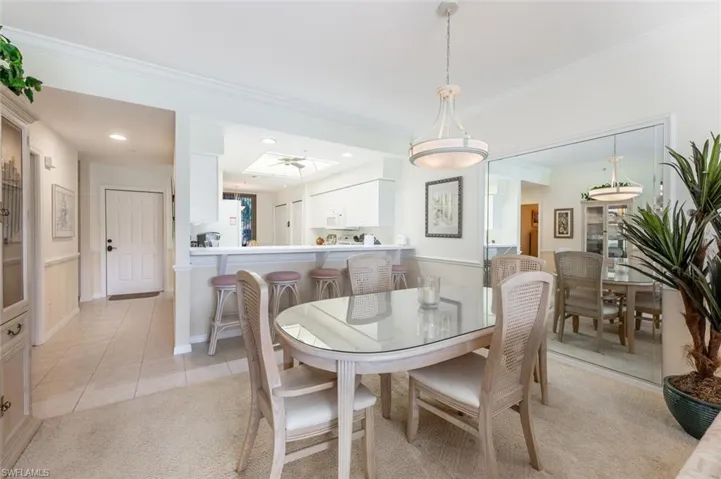 Dining space featuring crown molding and light tile patterned flooring