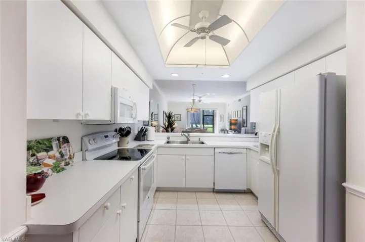 Kitchen featuring white cabinets and white appliances