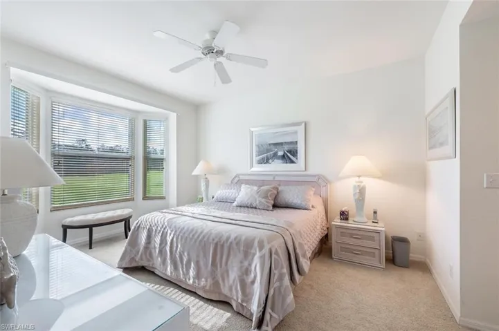 Carpeted bedroom featuring ceiling fan