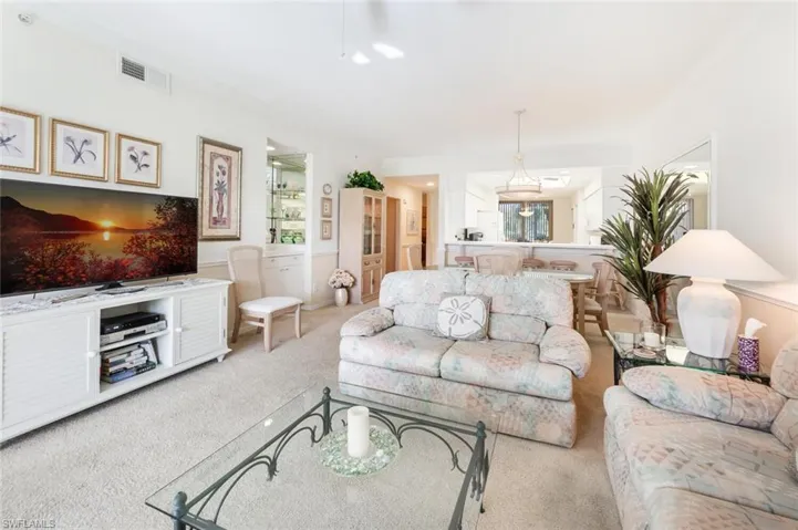 Carpeted living room featuring ornamental molding
