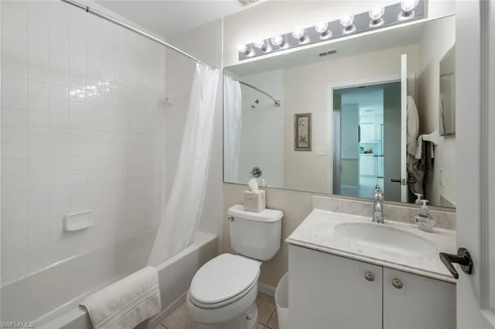 Full bathroom featuring vanity, shower / tub combo, tile patterned floors, and toilet