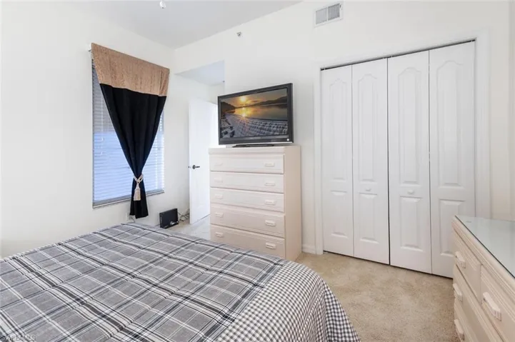 Unfurnished bedroom with light carpet and a closet
